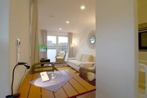 a living room with a couch and a table at NS 6a Seestern Wremen in Wremen +3 photos