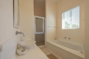 a bathroom with a sink and a toilet and a tub at 53 Island Road in Seafield +3 photos