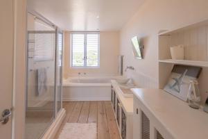 a white bathroom with a tub and a sink at 53 Island Road in Seafield