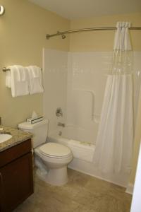 a bathroom with a white toilet and a shower at Affordable Suites of America Augusta in Augusta