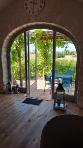 an archway in a room with a table and a patio at Gîte du Clos de Gamel in Lascabanes