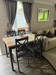 a table and chairs in a living room with a couch at 23 The Brambles - Haven Cleethorpes Beach in Humberston