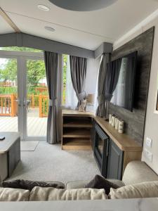 a living room with a couch and a television at 23 The Brambles - Haven Cleethorpes Beach in Humberston