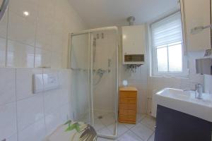 a bathroom with a shower and a sink at LT 33 Bungalow Manu in Dorum-Neufeld +3 photos