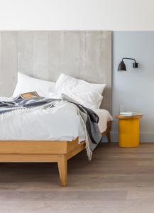 1 dormitorio con 1 cama con sábanas y almohadas blancas en Leman Locke, en Londres