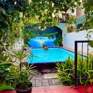 a large swimming pool with a man in the water at Eco Boutique Villa in Gurudeniya