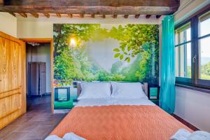 a bed in a room with a painting on the wall at Casale Rialto in Montefalco