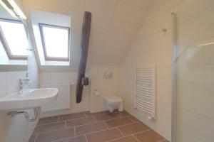 a bathroom with a sink and a toilet and a shower at Gästehaus Dorum 05 in Dorum