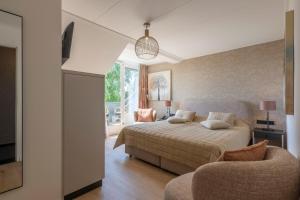 a bedroom with a bed and a tv and a couch at Hotel Inkelshoes in Epen