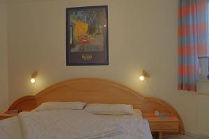 a bedroom with a wooden bed with two pillows at LT35 Bungalow Moritz in Dorum-Neufeld