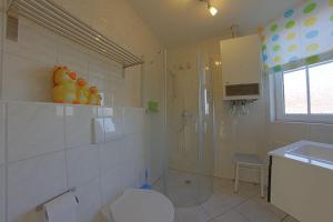 a bathroom with a shower and a toilet and a sink at LT35 Bungalow Moritz in Dorum-Neufeld +18 photos