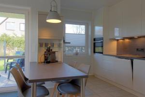 a kitchen with a table and chairs in a room at SI5-01 Terrassenwohnung Deichnah in Cappel-Neufeld