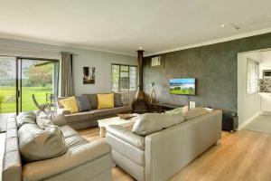 a living room with two couches and a table at Vaal River House @ Lochvaal in Vanderbijlpark