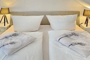 a bedroom with two white beds with pillows at Pusteblume in Lübbenau