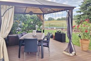 a wooden deck with a table and chairs under a canopy at Pusteblume in Lübbenau