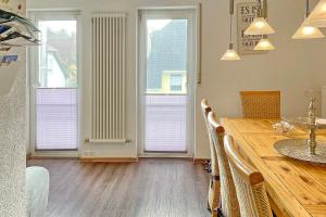 a dining room with a wooden table and three windows at Pusteblume in Lübbenau +17 photos