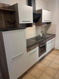 a kitchen with white cabinets and a sink at Penzion U Zvonu in Rychnov nad Kněžnou