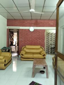 a living room with a couch and a brick wall at Mini Banglo in Sylhet +1 photo