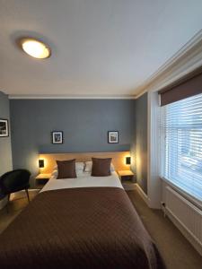 a bedroom with a large bed and a window at Hazeldene Guest House in Perth