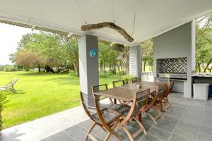 a wooden table and chairs on a patio at Vaal River House @ Lochvaal in Vanderbijlpark