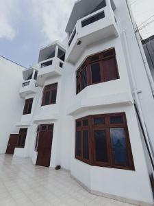 a white building with wooden doors and windows at Hotel Hari mangalam heritage in Tehri-Garhwāl