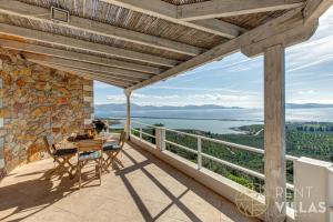 a view from the balcony of a house with a table and chairs at Villa Karima with Sea View in Metókhion
