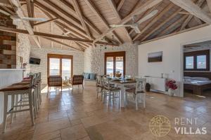 a kitchen and dining room with a table and chairs at Villa Karima with Sea View in Metókhion