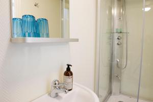 a bathroom sink with a bottle of soap on it at Lilla Hotellet i Nora in Nora +29 photos
