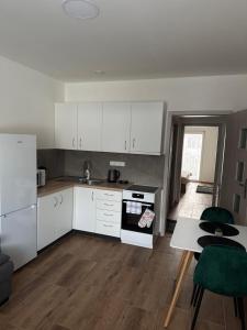 a kitchen with white cabinets and a table and a tableablish at Apartmán ALEX Choceň in Choceň