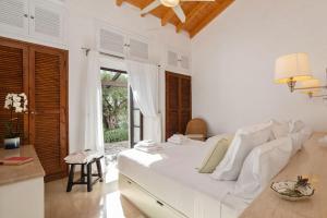 a white bedroom with a bed and a window at Spartilas Villas in Pyrgi +101 photos