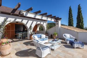 a patio with chairs and a pergola at Spartilas Villas in Pyrgi