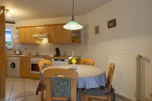 a kitchen with a table and chairs and a kitchen with a sink at STW28a Delphin in Dorum-Neufeld