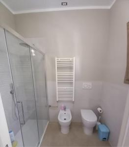 a white bathroom with a toilet and a shower at Casa Tella in Pula +10 photos