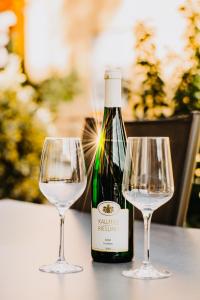 a bottle of wine and two wine glasses on a table at Residenz Mont Royal in Traben-Trarbach