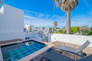 a villa with a swimming pool and a deck with a palm tree at 14 Travessa das Naus in Carvoeiro