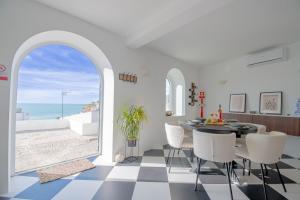 a dining room with a table and a view of the ocean at 14 Travessa das Naus in Carvoeiro