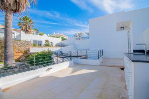 a white house with stairs and a palm tree at 14 Travessa das Naus in Carvoeiro