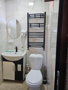a bathroom with a white toilet and a sink at For Family in Aparan