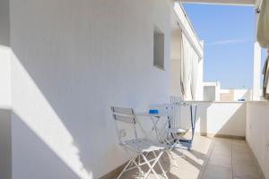 a white room with a chair and a window at Salaqua Bed and Breakfast in Torre Mozza