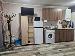 a kitchen with a refrigerator and a washing machine at For Family in Aparan