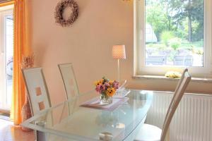 a glass dining room table with a vase of flowers on it at Herz in Lübbenau