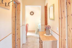 a hallway with a table with a vase on it at Herz in Lübbenau +19 photos