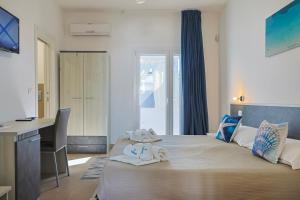 a bedroom with a bed with towels on it at Salaqua Bed and Breakfast in Torre Mozza