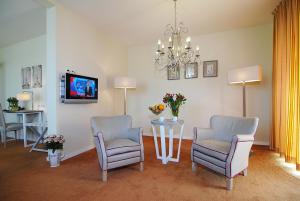 a living room with two chairs and a table and a tv at Hotel Inkelshoes in Epen