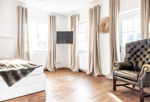 a bedroom with a bed and a chair and windows at Villa Stella all famous ski areas around us, 15 minutes to salzburg, mountainview in Golling an der Salzach