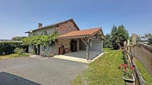 a small brick house with a garage in a yard at Les tâches in Pensol