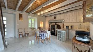 a large kitchen with a table and chairs in it at Les tâches in Pensol