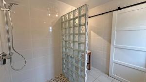 a shower with a glass door in a bathroom at Les tâches in Pensol +24 photos