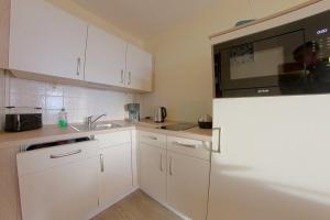 a kitchen with white cabinets and a white refrigerator at Apartment 545 in Hohegeiß