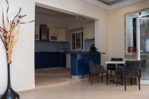 a kitchen with blue cabinets and a table and chairs at Dar Gamra in Tozeur